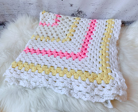 Pastel pink and yellow knitted blanket